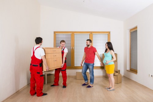 Staff using gloves and safe handling methods while moving furniture
