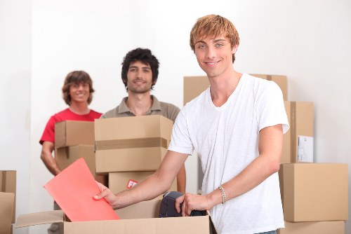 Movers carrying household furniture through a narrow hallway